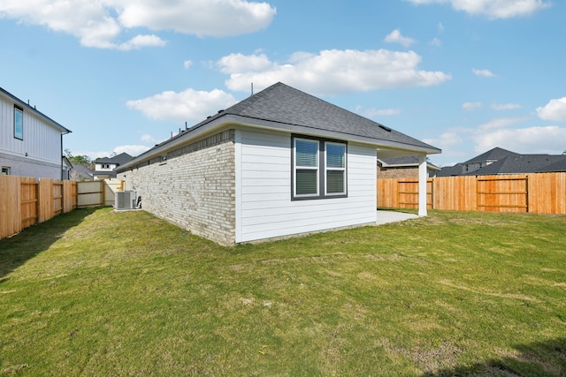 back of house featuring a lawn and central AC