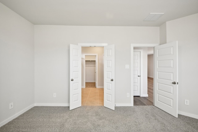 unfurnished bedroom featuring a spacious closet and carpet