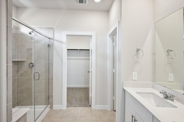 bathroom with tile patterned flooring, vanity, and a shower with door