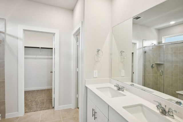 bathroom featuring tile patterned flooring, vanity, and walk in shower