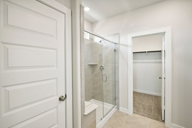 bathroom with tile patterned flooring and a shower with shower door