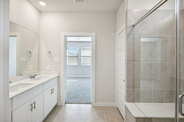 bathroom featuring tile patterned flooring, vanity, and a shower with shower door