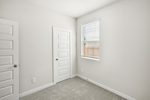 unfurnished room with light colored carpet