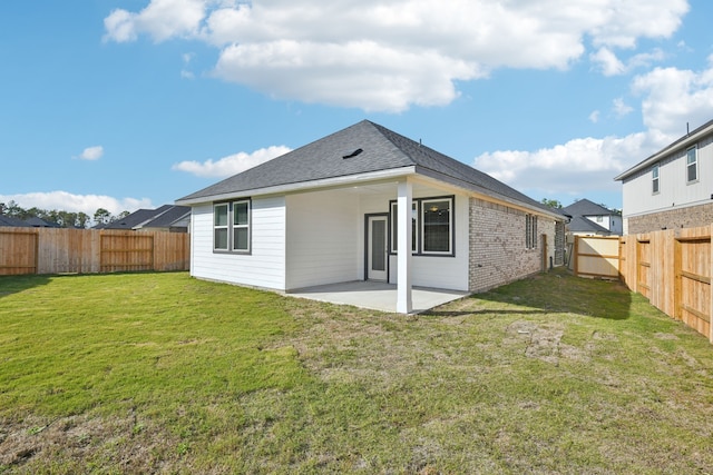 rear view of property featuring a patio area and a yard