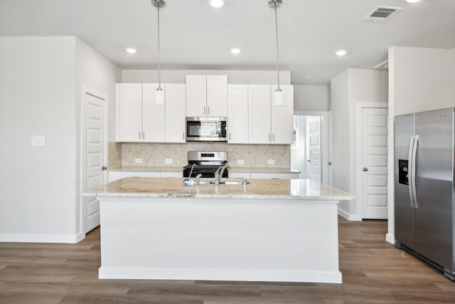 kitchen with white cabinets, appliances with stainless steel finishes, decorative light fixtures, and dark wood-type flooring