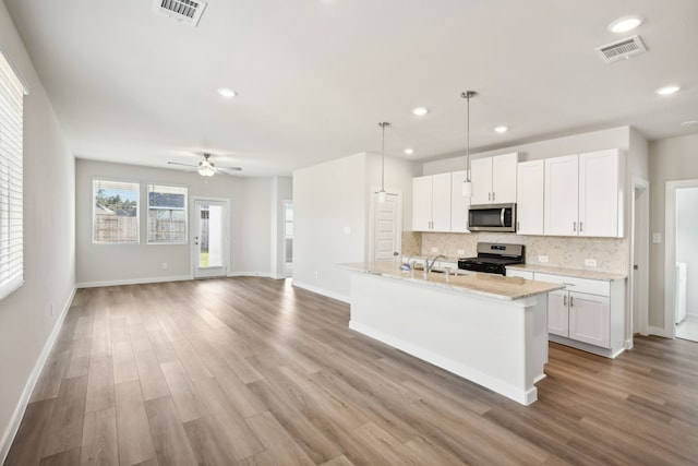 kitchen with stainless steel appliances, ceiling fan, light hardwood / wood-style flooring, white cabinets, and hanging light fixtures