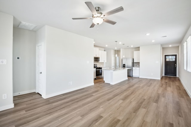 unfurnished living room featuring ceiling fan and light hardwood / wood-style floors