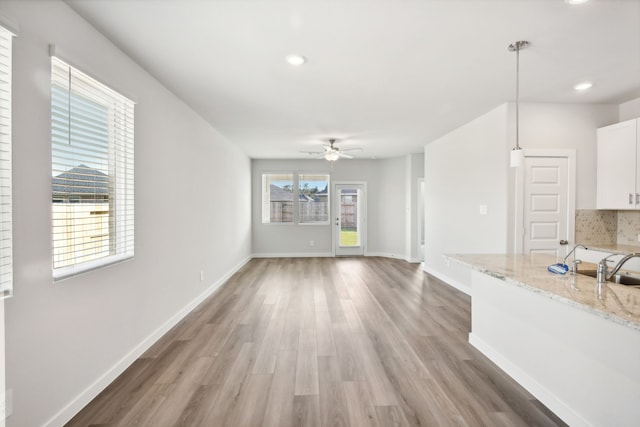 unfurnished living room featuring hardwood / wood-style flooring and ceiling fan