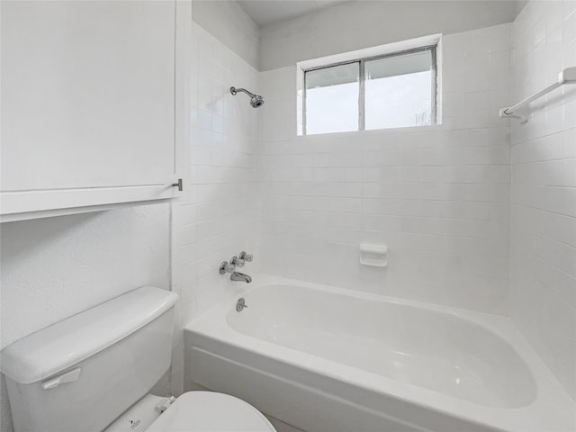 bathroom featuring toilet and tiled shower / bath combo