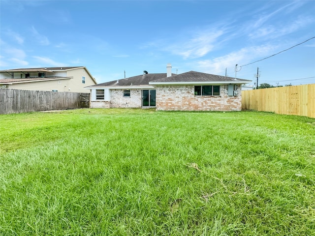 rear view of house with a yard