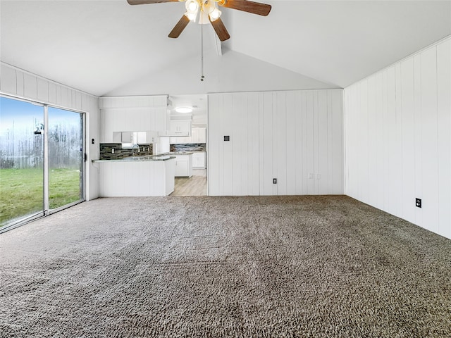 unfurnished living room featuring ceiling fan, lofted ceiling with beams, and light hardwood / wood-style floors