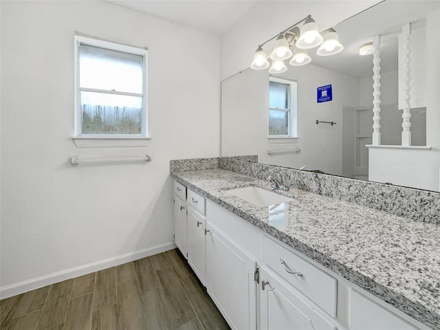 bathroom with vanity, a healthy amount of sunlight, and hardwood / wood-style floors