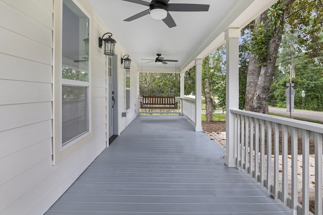 wooden terrace with ceiling fan and covered porch