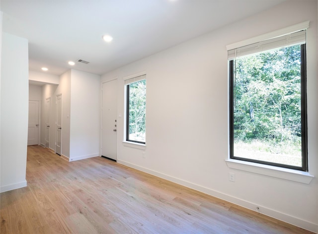 unfurnished room with plenty of natural light and light hardwood / wood-style floors