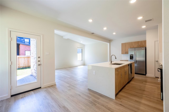 kitchen with light wood-type flooring, appliances with stainless steel finishes, plenty of natural light, and sink