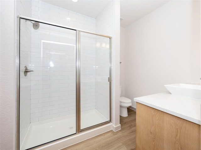 bathroom with vanity, toilet, an enclosed shower, and hardwood / wood-style flooring