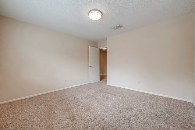 carpeted empty room featuring a textured ceiling