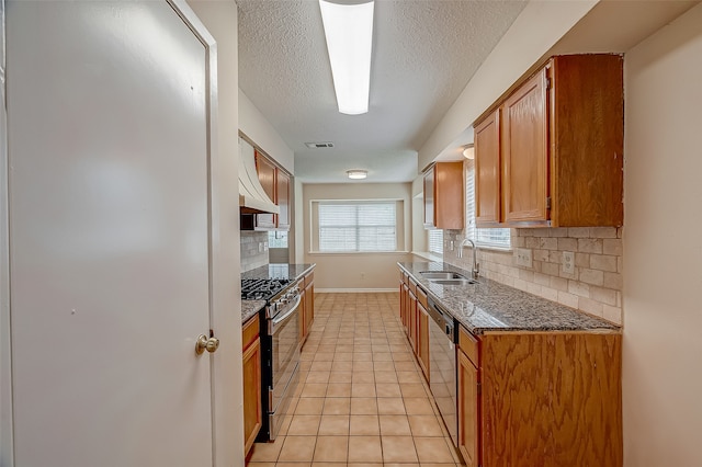 kitchen with appliances with stainless steel finishes, light tile patterned floors, tasteful backsplash, and sink