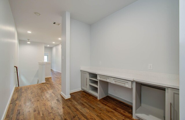 interior space featuring built in desk and dark hardwood / wood-style floors