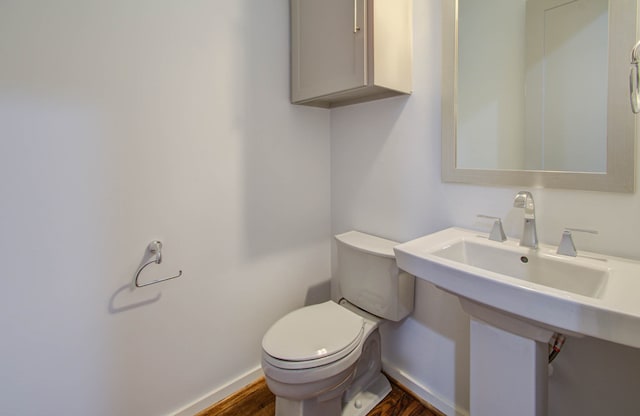 bathroom with hardwood / wood-style floors and toilet