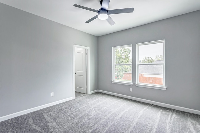 carpeted spare room with ceiling fan