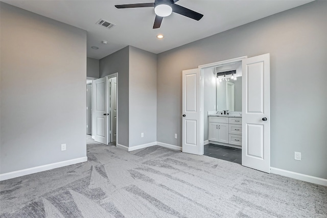 unfurnished bedroom featuring ensuite bath, ceiling fan, and carpet