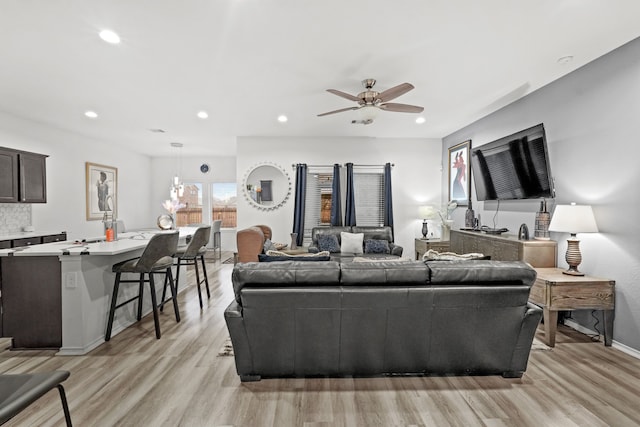 living room featuring ceiling fan and light hardwood / wood-style floors