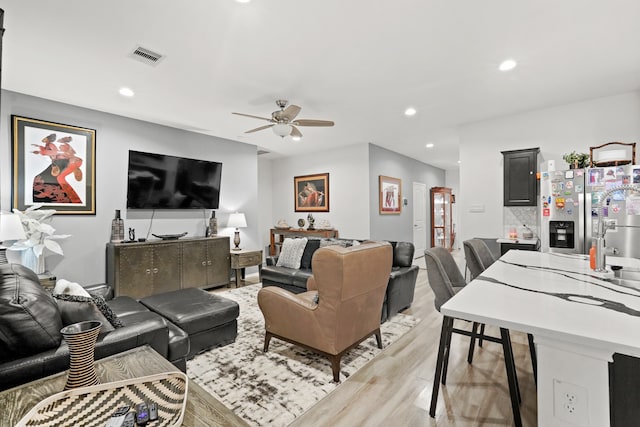 living room featuring ceiling fan and light wood-type flooring