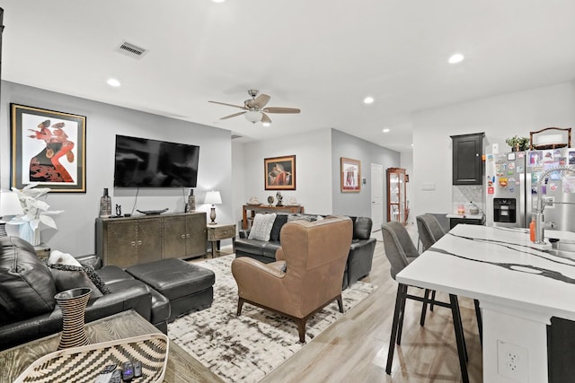 living room featuring recessed lighting, light wood-style floors, visible vents, and ceiling fan