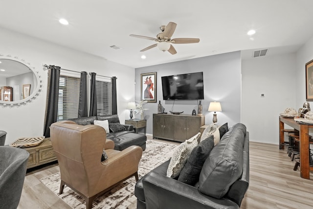 living room featuring light hardwood / wood-style flooring and ceiling fan