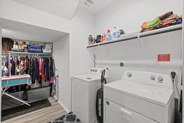 clothes washing area featuring light wood-type flooring and washing machine and clothes dryer