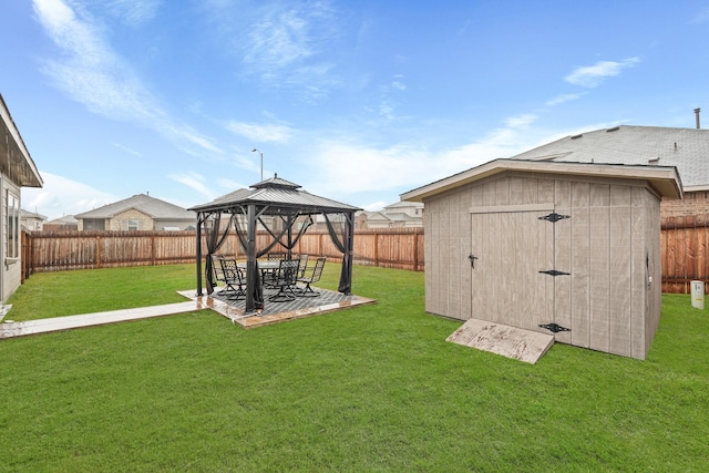 view of yard featuring a gazebo, a storage shed, a fenced backyard, an outdoor structure, and a patio area