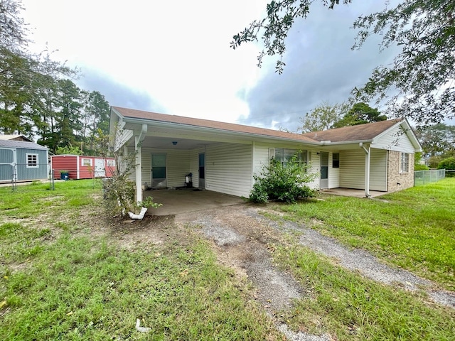 rear view of property featuring a carport and a lawn