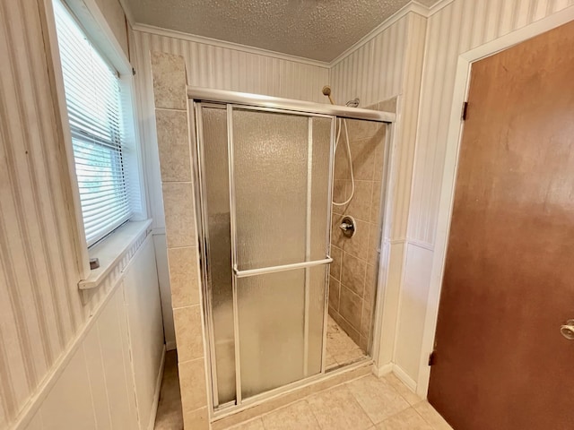 bathroom featuring a shower with door, a textured ceiling, and tile patterned flooring