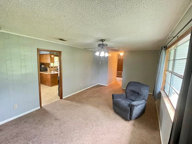 unfurnished room with ornamental molding, carpet, and ceiling fan