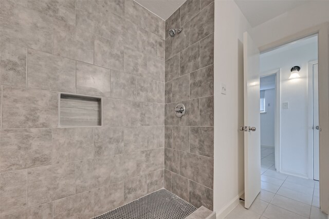 bathroom with a tile shower and tile patterned floors