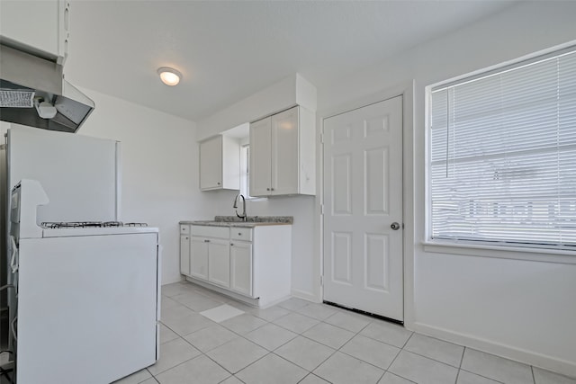 kitchen featuring white cabinetry, extractor fan, light tile patterned floors, and sink