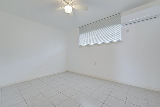 spare room featuring an AC wall unit, ceiling fan, and light tile patterned floors