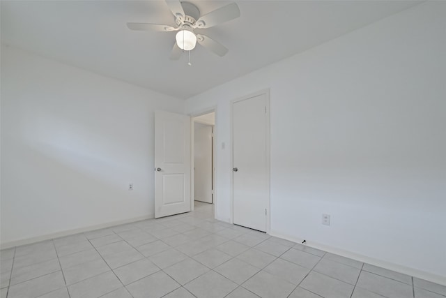 tiled spare room featuring ceiling fan