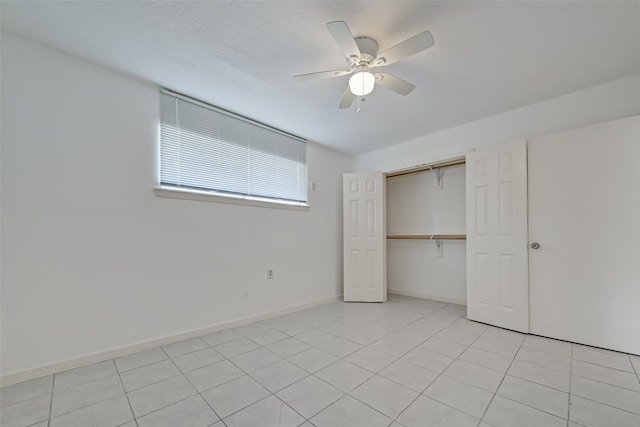 unfurnished bedroom featuring light tile patterned floors, ceiling fan, and a closet