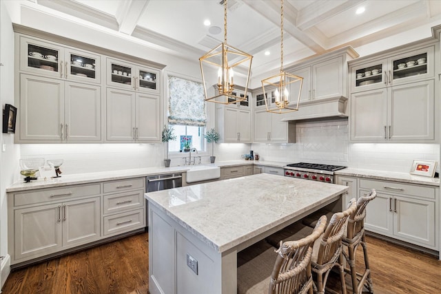 kitchen with a kitchen island, coffered ceiling, a sink, and dark wood finished floors