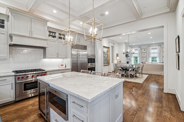 kitchen with built in appliances, beamed ceiling, dark wood finished floors, and an inviting chandelier