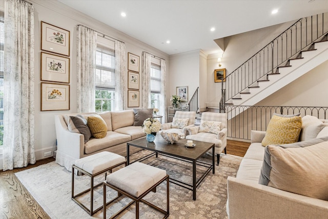 living room featuring baseboards, stairs, ornamental molding, and wood finished floors