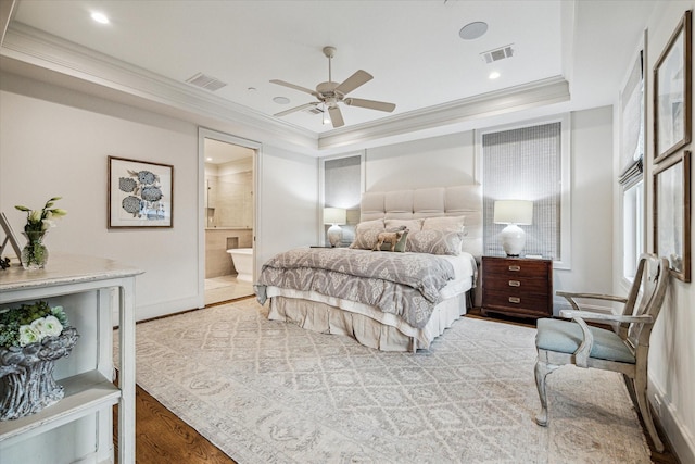 bedroom with a raised ceiling, ornamental molding, wood finished floors, and visible vents