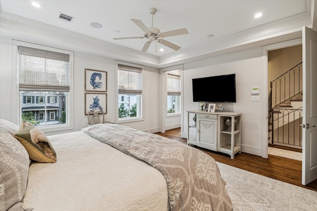 bedroom with ornamental molding, wood finished floors, visible vents, and recessed lighting