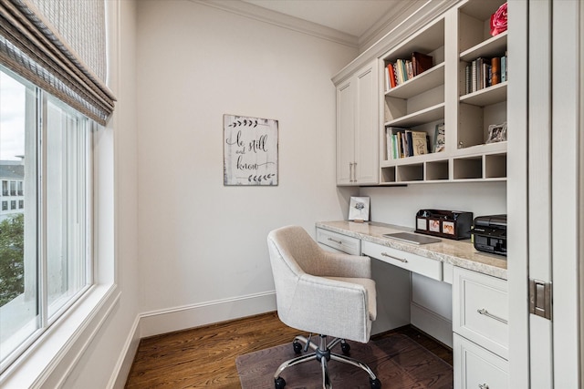 office area with dark wood-type flooring, built in study area, crown molding, and baseboards