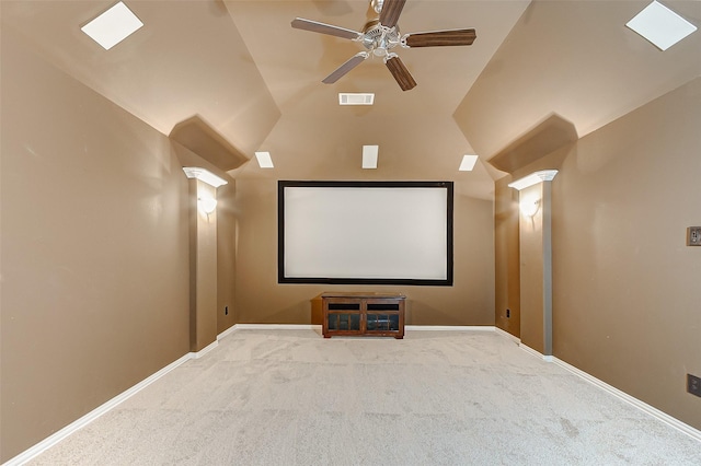 home theater room featuring baseboards, visible vents, lofted ceiling, and carpet floors