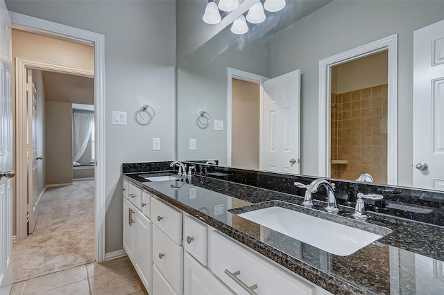 bathroom with tile patterned floors, double vanity, baseboards, and a sink