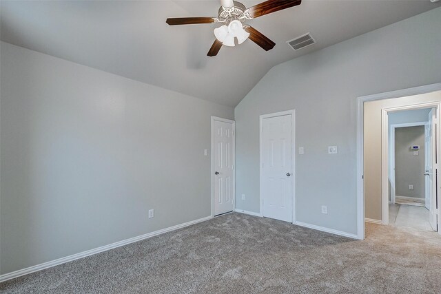 unfurnished bedroom with visible vents, carpet floors, baseboards, ceiling fan, and vaulted ceiling