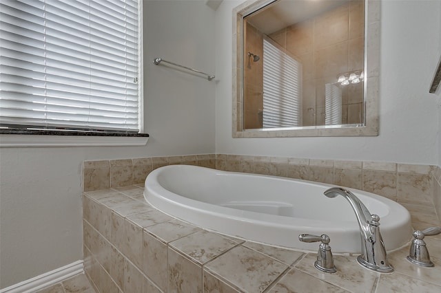 bathroom with a relaxing tiled tub and tile patterned floors